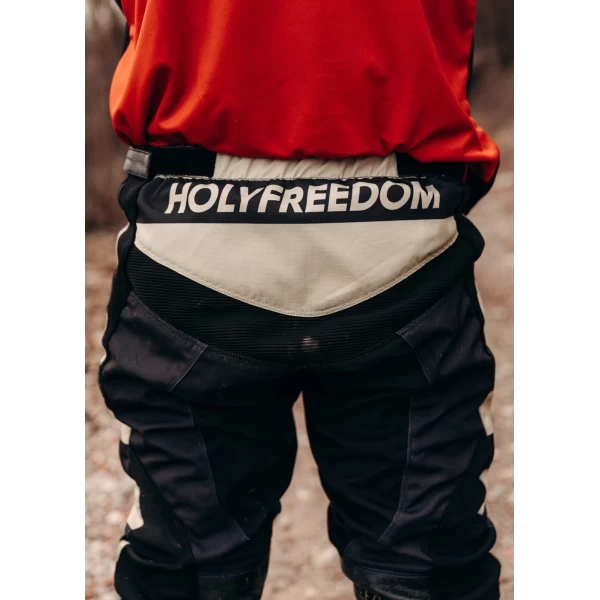 Close-up of the black technical fabric and details on Mud Black scrambler trousers.