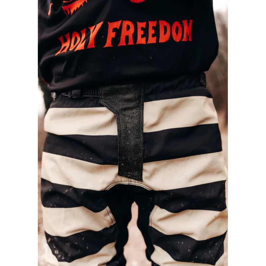 Close-up of the black technical fabric and details on Mud Black scrambler trousers.