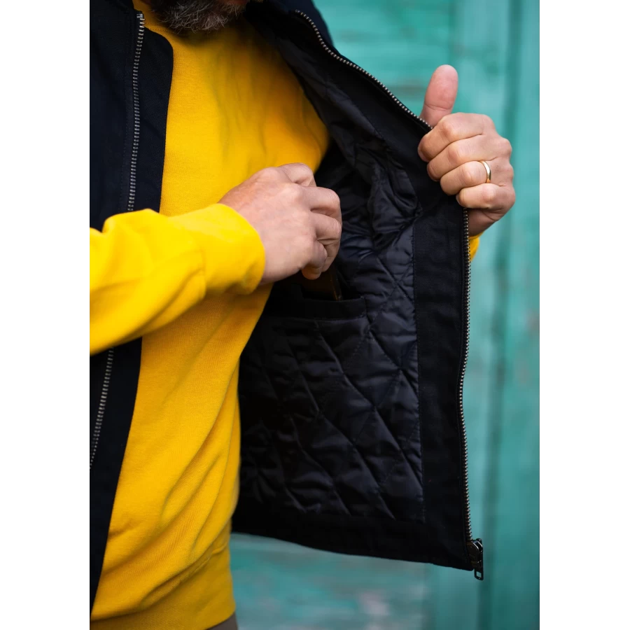 Dettaglio del gilet nero imbottito con anima worker e stile moto vintage.