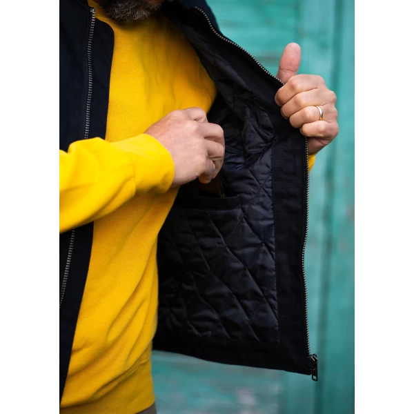 Dettaglio del gilet nero imbottito con anima worker e stile moto vintage.