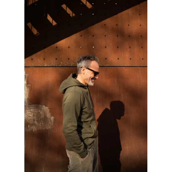 Holyfreedom green hoodie worn in the city for an easy rider lifestyle look.