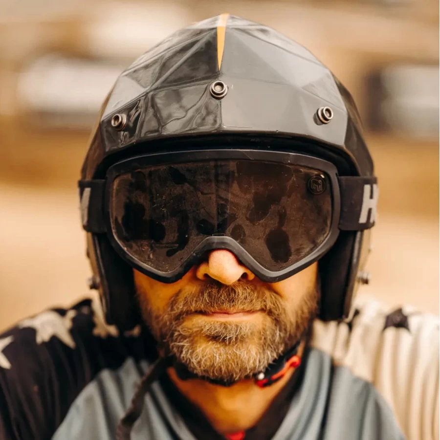 Occhiali moto vintage indossati con casco jet e giacca cafe racer per uno stile urbano forte.