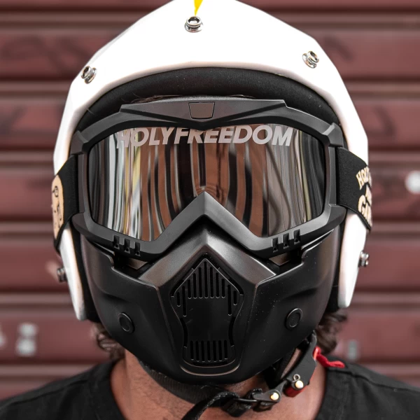 Maschera moto vintage abbinata a casco jet e giacca scrambler per un outfit autentico.