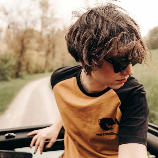 Fit femminile con t-shirt raglan Holyfreedom, perfetta per look cafe racer casual e quotidiano.