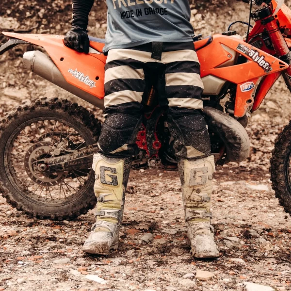 Close-up of the black technical fabric and details on Mud Black scrambler trousers.