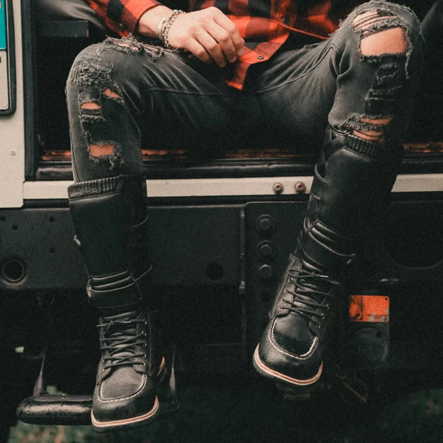 Stivali moto alti in abbinamento a denim e giacca per un look custom deciso.