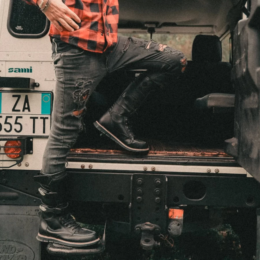 Stivali moto alti in abbinamento a denim e giacca per un look custom deciso.