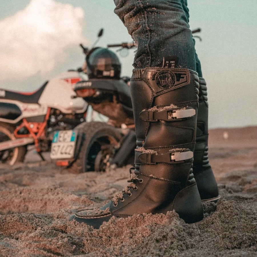 Dettaglio del gambale alto con finiture vintage e protezione CE per uso moto.