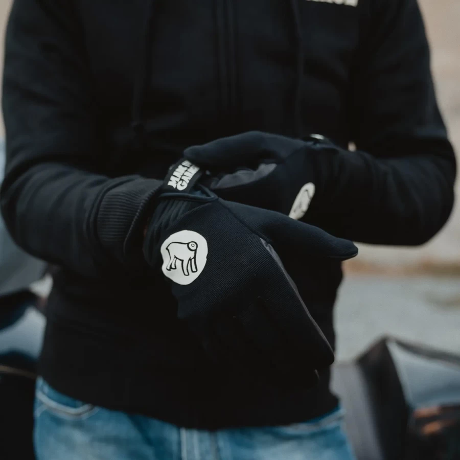 Gloves worn on a rider, pairing custom motorcycle style with everyday street comfort.