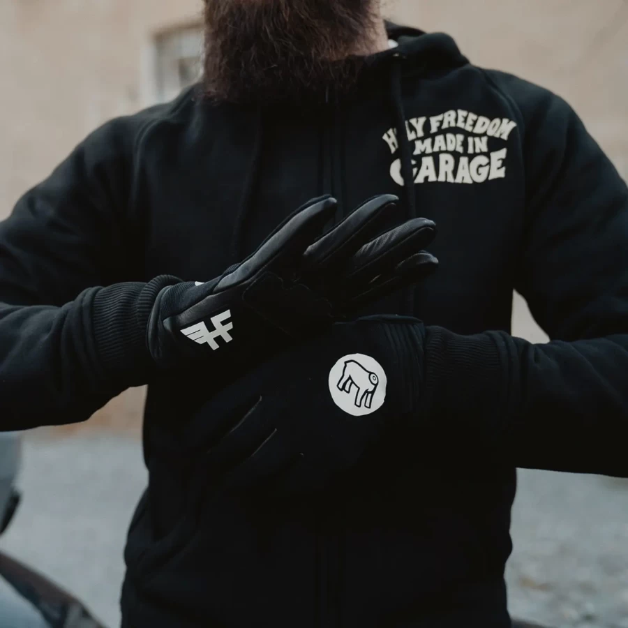 Gloves worn on a rider, pairing custom motorcycle style with everyday street comfort.