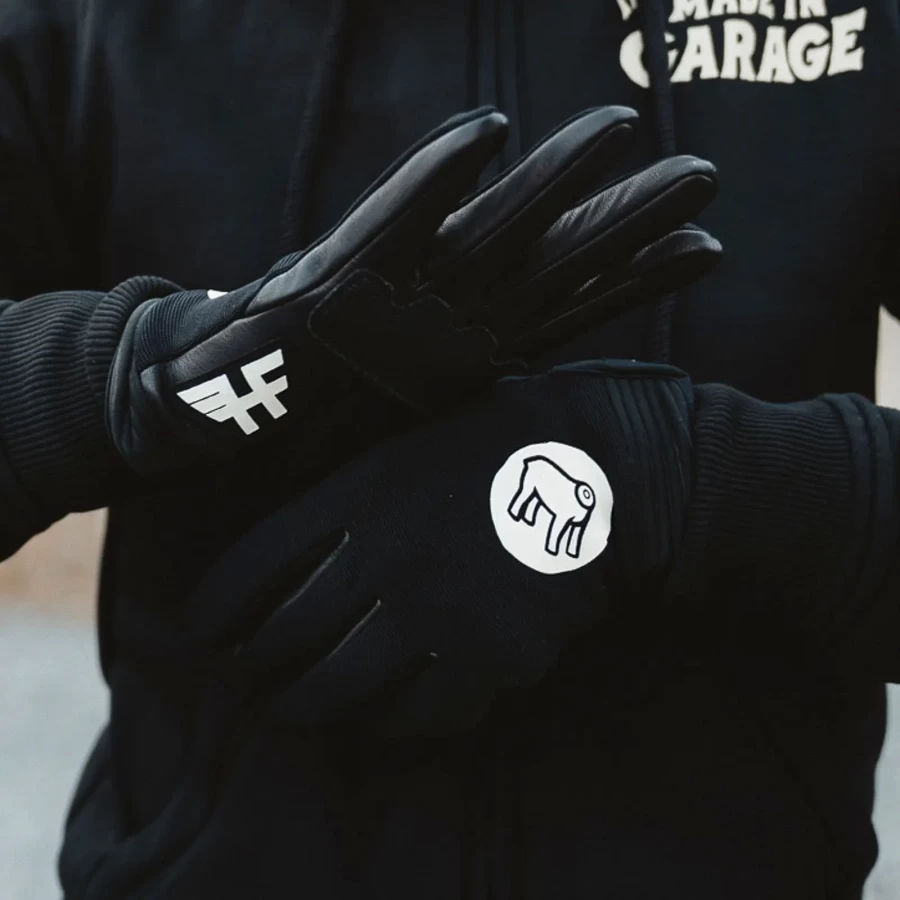Gloves worn on a rider, pairing custom motorcycle style with everyday street comfort.