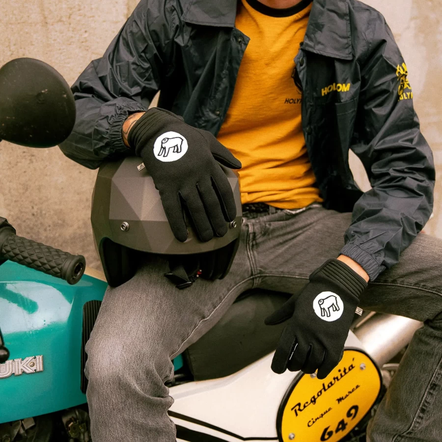 Gloves worn on a rider, pairing custom motorcycle style with everyday street comfort.