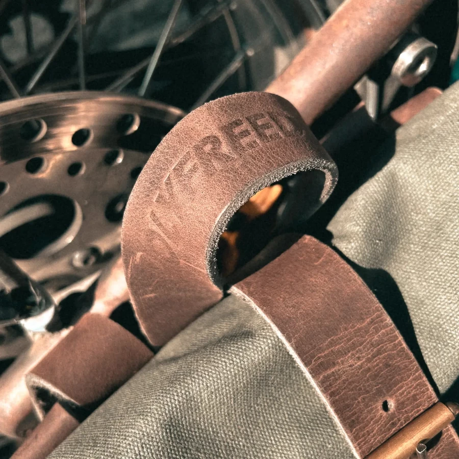 Detail of the green backpack roll-top closure and metal plate mounting system