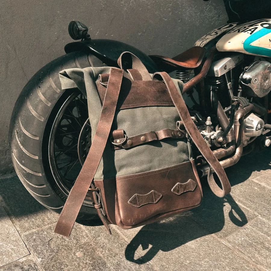 Detail of the green backpack roll-top closure and metal plate mounting system