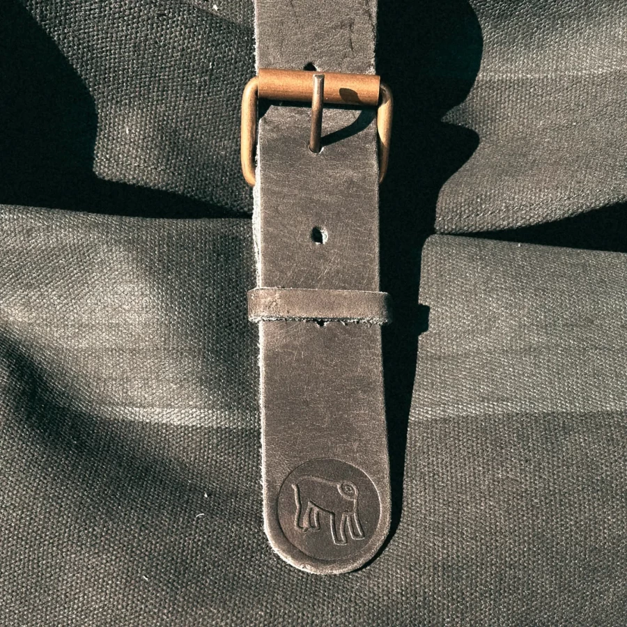 Detail of the black backpack roll-top closure and strap or plate mounting system
