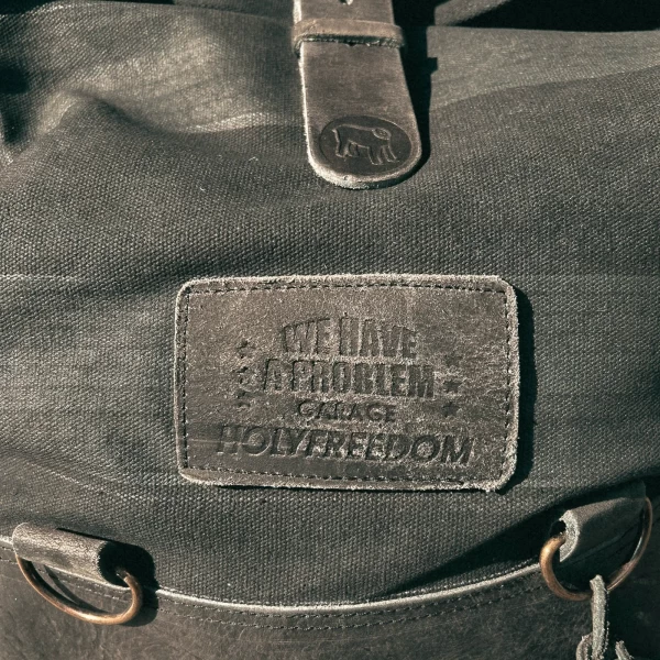 Detail of the black backpack roll-top closure and strap or plate mounting system