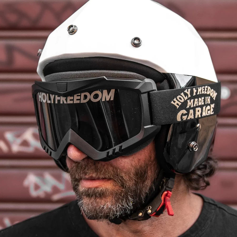 Occhiali moto vintage indossati con casco jet e giacca cafe racer per un look urbano autentico.