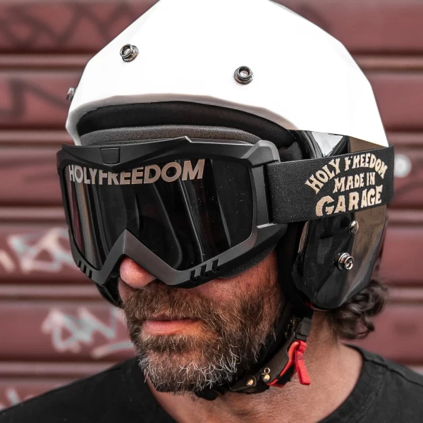 Occhiali moto vintage indossati con casco jet e giacca cafe racer per un look urbano autentico.