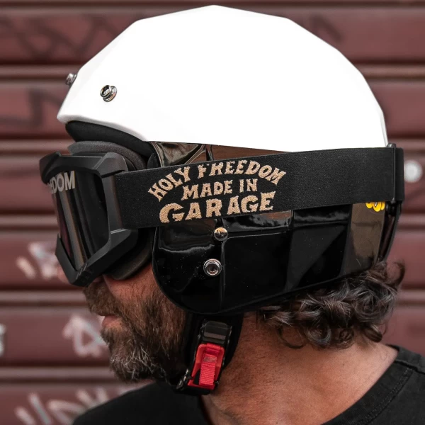 Occhiali moto vintage indossati con casco jet e giacca cafe racer per un look urbano autentico.