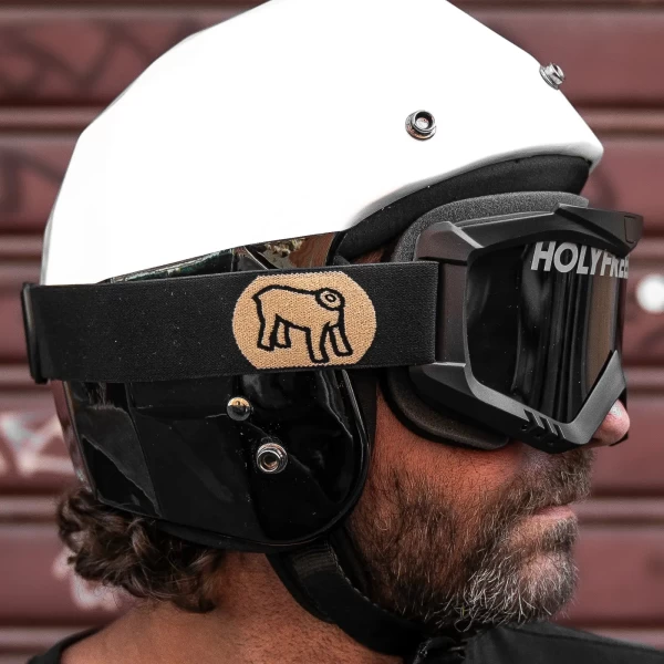 Occhiali moto vintage indossati con casco jet e giacca cafe racer per un look urbano autentico.