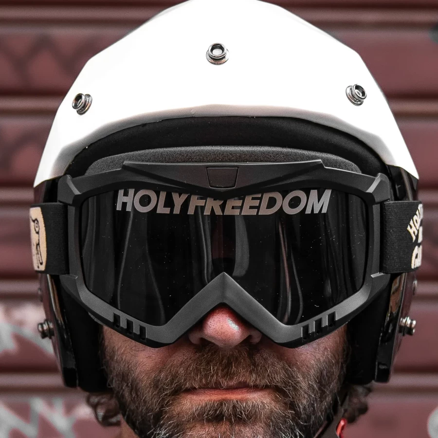 Occhiali moto vintage indossati con casco jet e giacca cafe racer per un look urbano autentico.