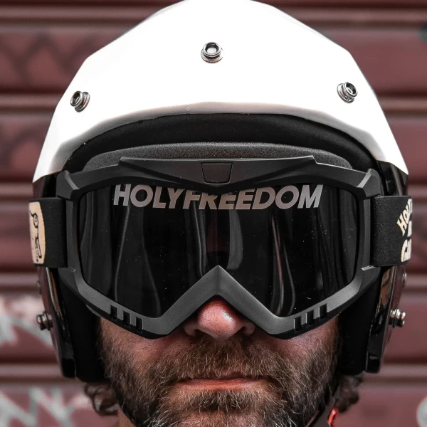 Occhiali moto vintage indossati con casco jet e giacca cafe racer per un look urbano autentico.