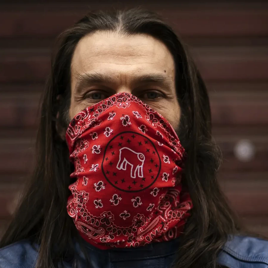 Rosso tube scarf worn with helmet and jacket for city rides and travel.