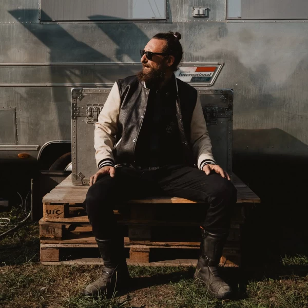 Black varsity jacket worn by a rider for motorcycle use and everyday street wear