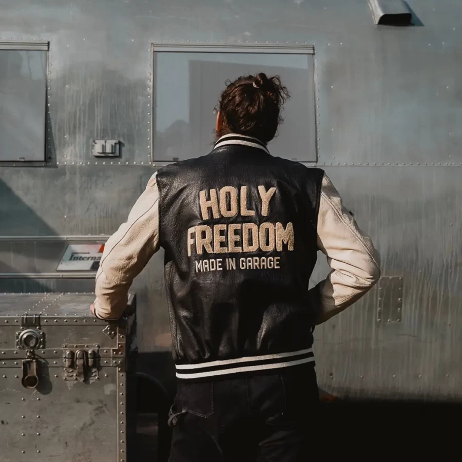 Black varsity jacket worn by a rider for motorcycle use and everyday street wear