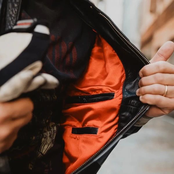 Close detail of the leather and stitching on the vintage riding jacket.